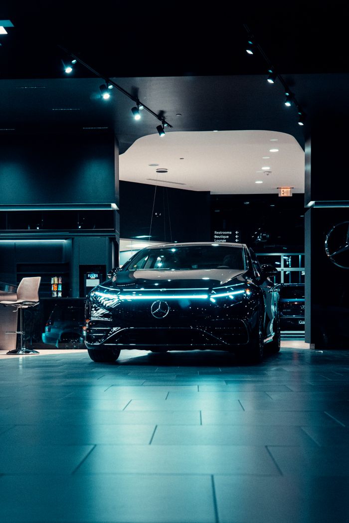 Luxurious black Mercedes-Benz displayed in a futuristic showroom setting.